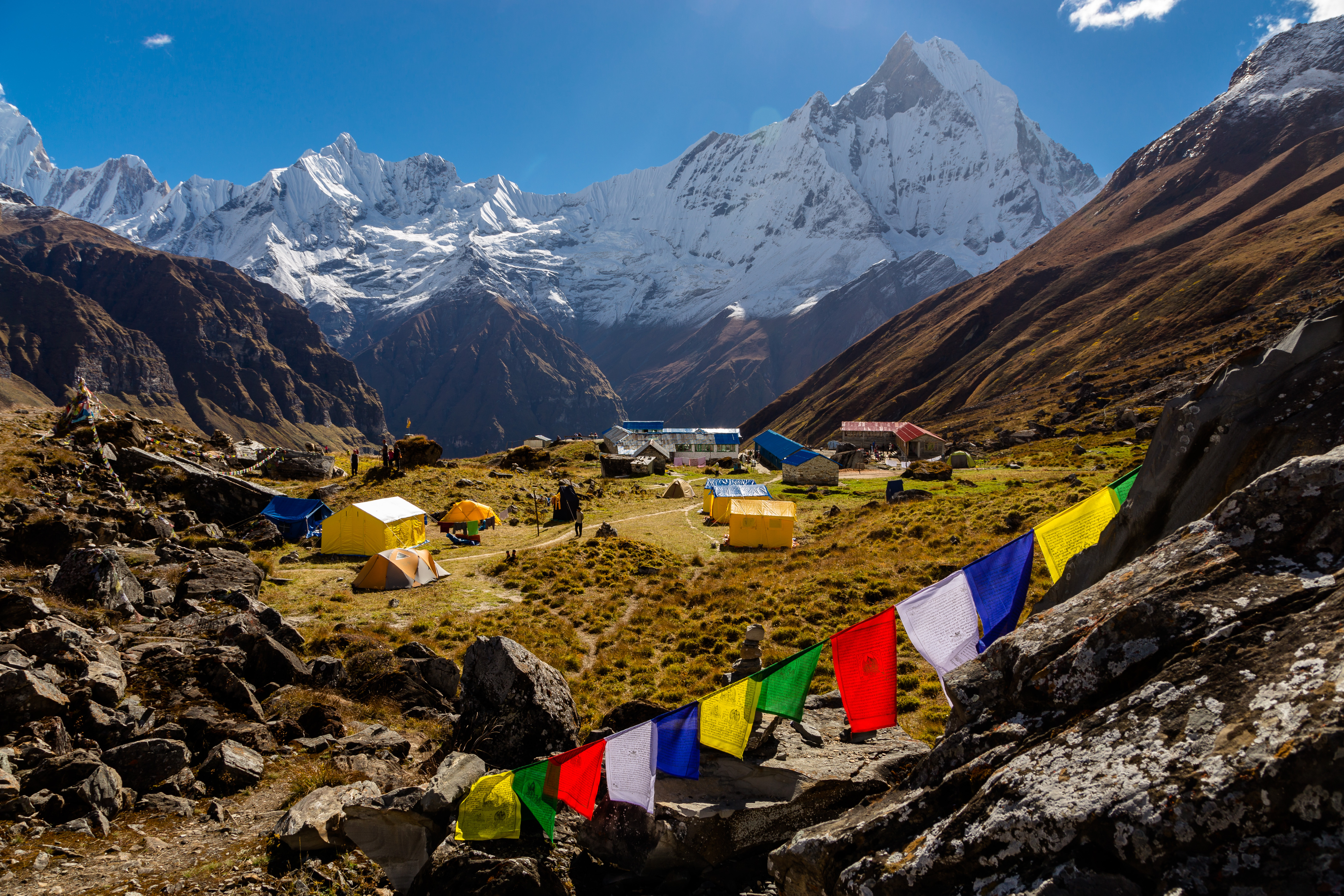 Annapurna Base Camp, in Nepal, with prayer flags in the foreground and the Himalayan mountains in the background
